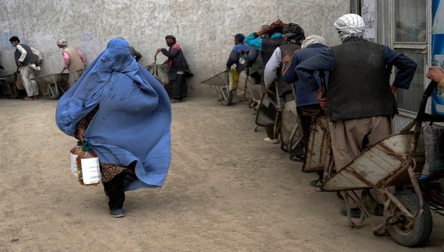 Taliban surround a woman in a pit and stone her